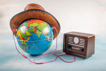  Globe, old radio and headphones isolated on blue background.