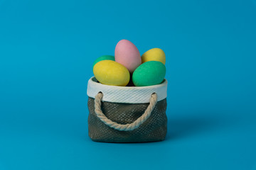 Colorful easter eggs with ceramic basket concept.