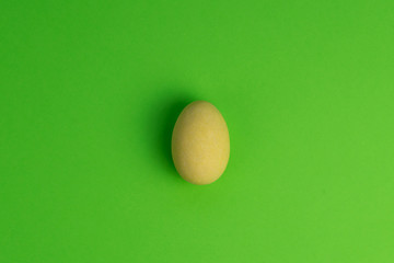 A yellow Easter egg isolated on a green background.