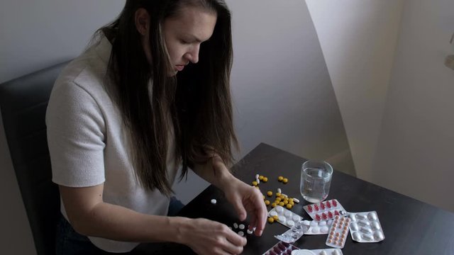 Suicide concept, Woman taking medicine overdose trying to kill herself, Sick girl taking a lot of pills.