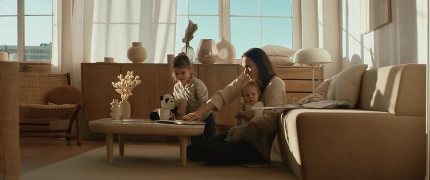 Mother working from home, having a phone call, while her daughters distract her and drawing attention. Shot on RED Dragon