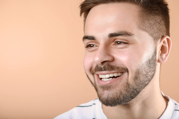 Obraz premium Handsome smiling young man on color background