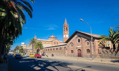 Asmara, Eritrea - November 01, 2019: Facade View to the Church of Our Lady of the Rosary and Palm Trees