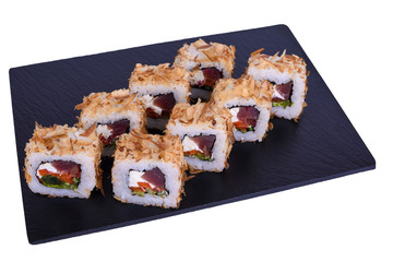 Traditional fresh japanese sushi rolls on black stone Bonito on a white background. Roll ingredients: tuna, philadelphia cheese, cucumber, tomato, tuna flakes, nori, rice.