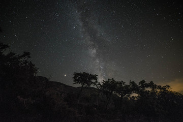 Colorful night landscape Milky Way over the mountains in the starry sky with hills in summer.
