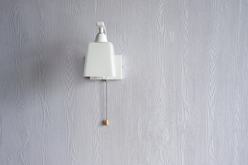 Minimalistic, stylish, white wall lamp on a blue wall. Stylish interior. Coziness.