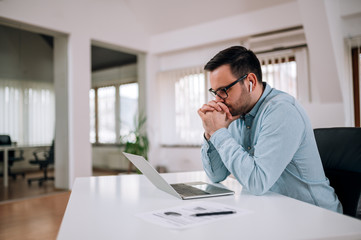 Naklejka premium Worried entrepreneur looking at laptop screen at workplace, portrait.