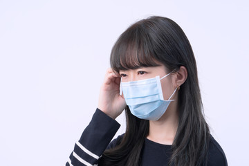 Young woman is feeling dizzy, headache, sick, unwell with wearing a medical blue face mask over the...