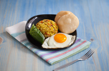 Asian fried rice homemade nasi goreng dish served with prawn crackers krupuk and sunny side up egg