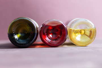 Bottom of  bottles with  red, pink, white wine on brown background
