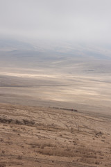 Masai crossing the plains of Ngorongoro Crater in Tanzania on a somewhat misty morning