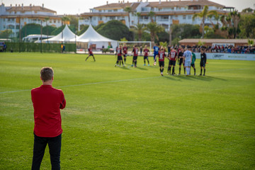 football coach watching his team in the preparation for a football match