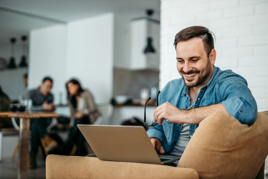 Portrait of a smiling man using laptop.