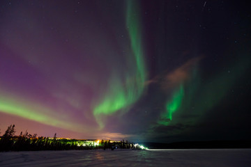 Multicolored green Violet vibrant Aurora Borealis Polaris, Northern Lights in night sky. Concept travel people
