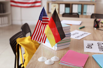 Flags of USA and German on table in language school