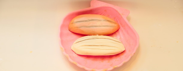 two soaps in a pink seashell in a bahtrooms sink 