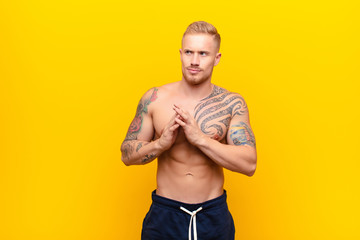 young strong blonde man scheming and conspiring, thinking devious tricks and cheats, cunning and...