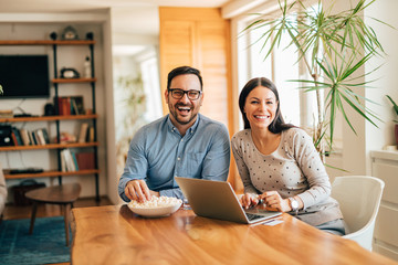 Portrait of a happy family, smiling at camera, sitting at table.