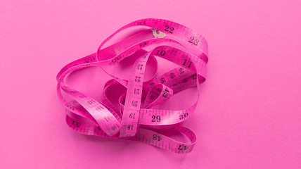 Pink centimeter on pink background. Simple flat lay with pastel texture. Fitness concept. Stock...