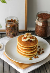 Pancakes served on a white plate. Delicious breakfast in the kitchen. Pancakes with slices of bananas 