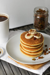 delicious pancakes with banana and raisins  on a white plate