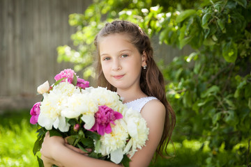 Beautiful little brunette girl with peonies