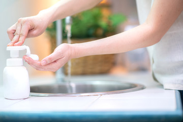 Close up of woman washing hand with liquid soap in the kitchen at home,prevent from corona virus or...