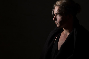 Fototapeta premium Profile portrait of a blond man on a black background. Beautiful, elegant, advertising