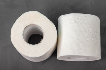 Two toilet paper rolls on a gray background