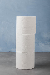three toilet paper rolls on a blue background