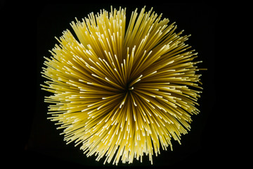 Raw spaghetti spiral shot from top on a black background.  Raw natural food concept