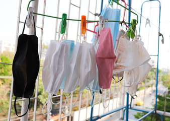Group of Face Masks Dirty with cosmatic Hanging on the clothes hanger at  the balcony against  protection infection  safe from coronavirus COVID-19 prevention of the spread of virus and pandemic