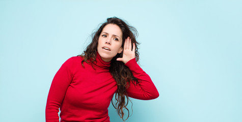 young pretty woman looking serious and curious, listening, trying to hear a secret conversation or...