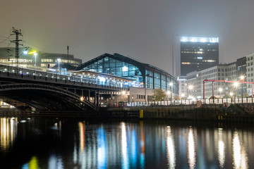 Fototapeta premium Bahnhof am Abend mit Spiegelung im Wasser und Brücke. Berlin. 