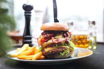 American big burger with a double cutlet, cheese, bacon, lettuce and sauce served with fries.