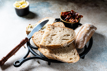 Bakery, crusty loaves of bread. Still life captured from above top view, flat lay . sun-dried tomatoes. Vegetarian food. Healthy food concept. Butter. Sandwich. sourdough bread.