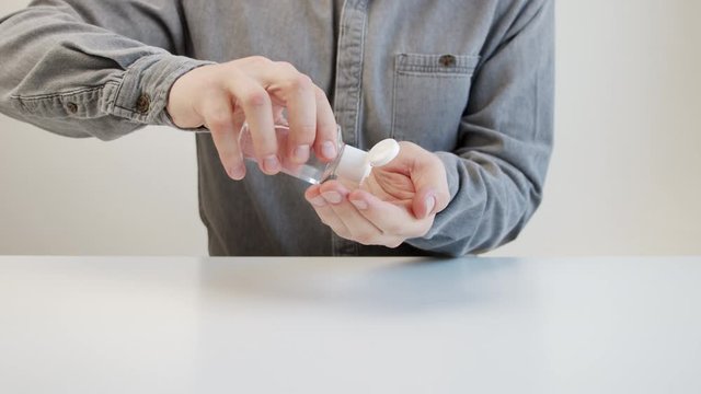Male uses liquid hand sanitizer to prevent coronavirus and bacteria