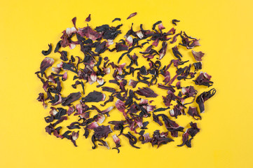 dry petals of a Sudanese tea rose on a yellow background top view