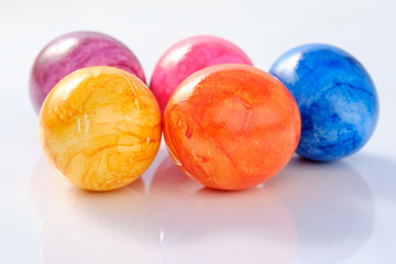 Five naturally looking coloured Easter eggs lying isolated on white background with copy space.