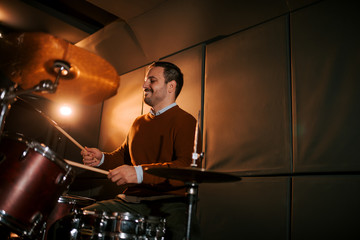 Fototapeta na wymiar Man playing on drum set in the studio, copy space.