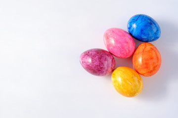 Five naturally looking coloured Easter eggs lying isolated on white background with copy space.