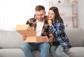 Young couple unpacking parcel at home