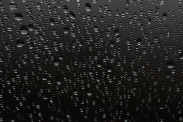 Water drops on gray background, top view