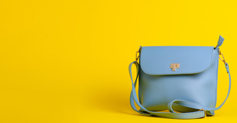 Blue fashion female woman purse handbag on yellow background