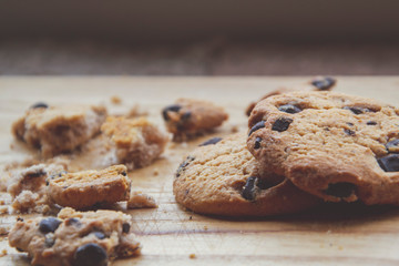 Close up picture of brown cookies with chocolate on wooden brown background, as handmade bakery with American taste of sweets, as home cooking concept and picture for wallpaper with sweet snack