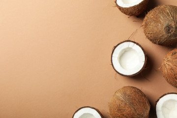 Coconuts on brown background, top view and space for text