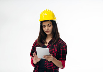 The young woman engineer with yellow safety helmet,using taplet for searching data about her work