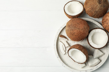 Tray with coconut on wooden background, top view. Tropical fruit