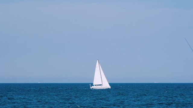 Ship Floating In Sea. Sailing boat with spinnaker sail in open sea