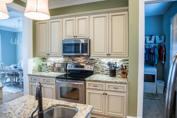 A small appliance microwave in a green kitchen with cream colored cabinets in a new construction...